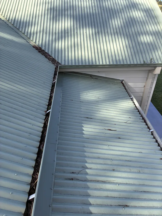 The same metal roof and guttering before exterior cleaning